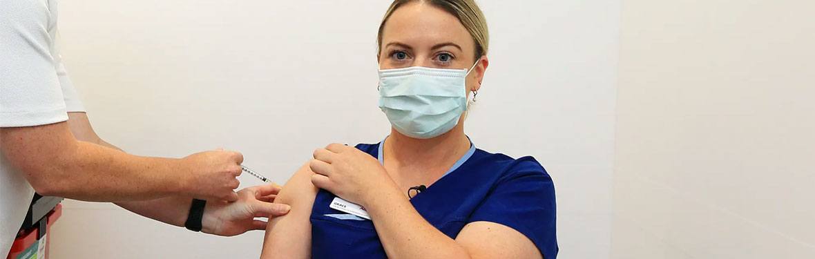 An Austin Health nurse receives her COVID-19 vaccination